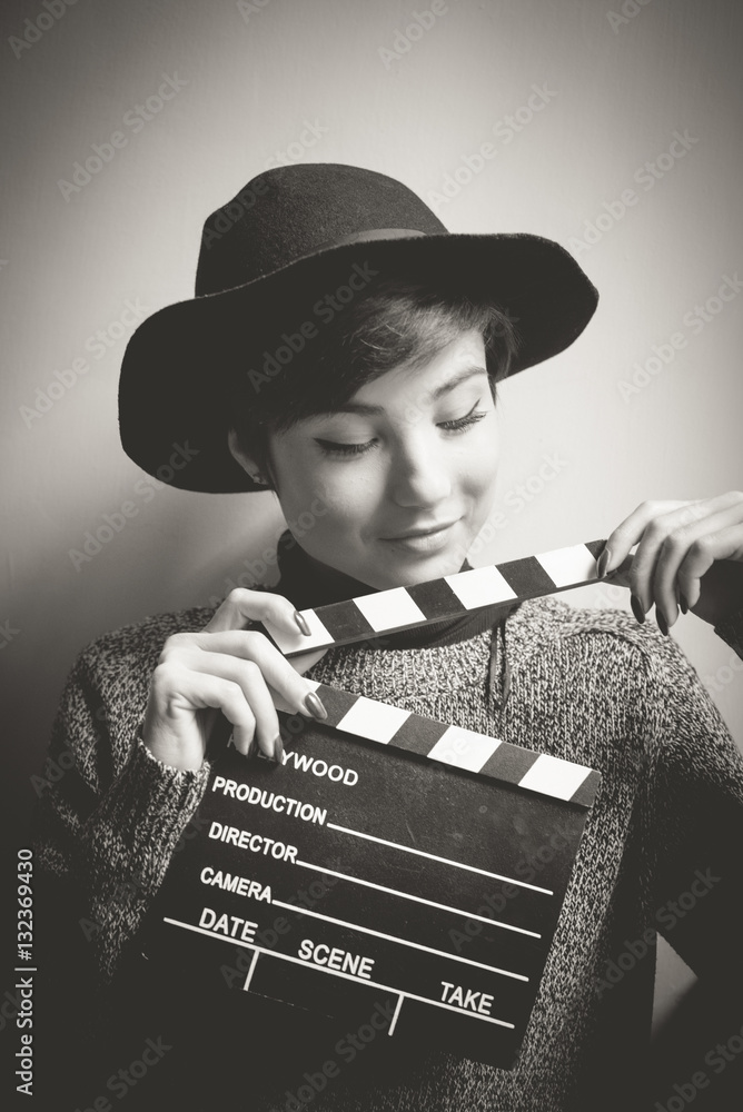 Fototapeta premium Portrait of young actress holding a movie clapper