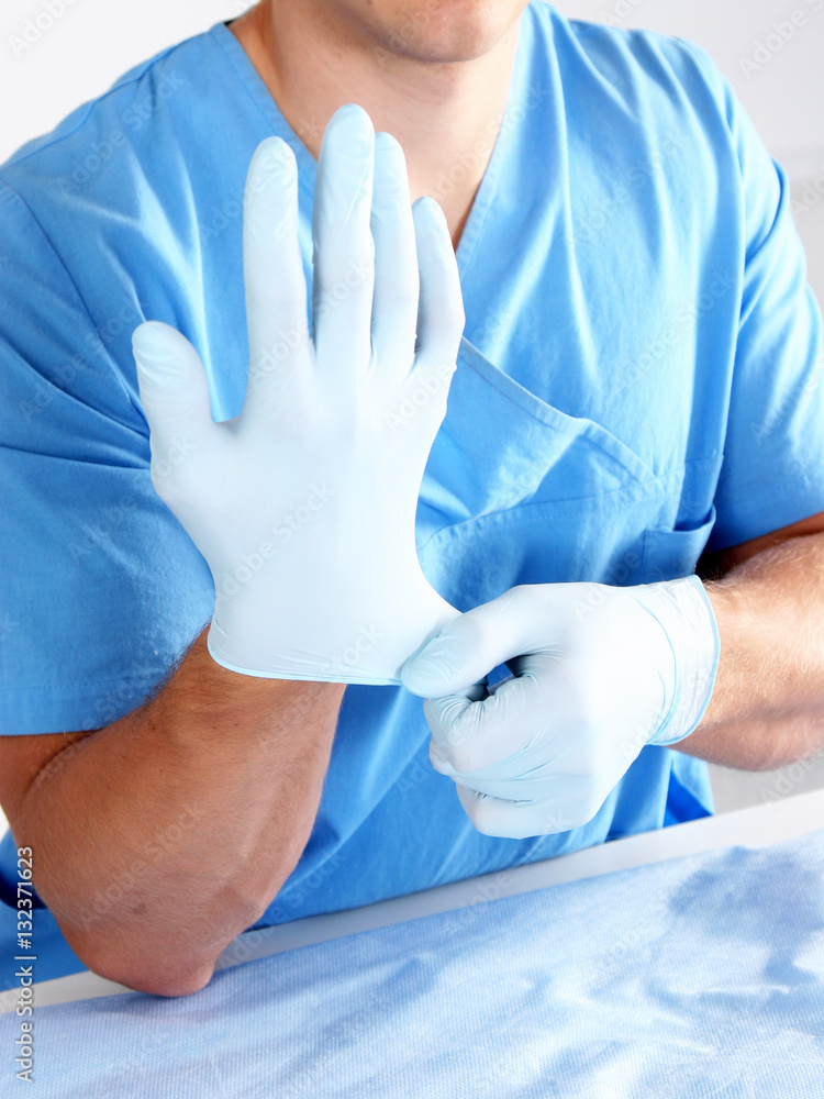 Doctor putting on sterile gloves isolated white Doctor putting on sterile gloves isolated white