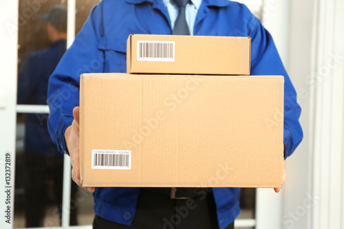 Courier with parcels on doorstep, closeup