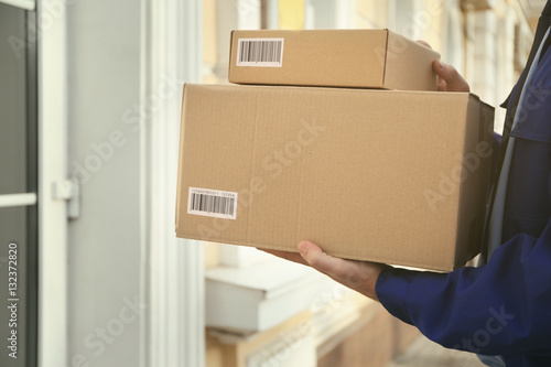 Fotografi Courier with parcels on doorstep, closeup