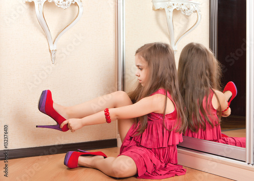 Photography Little girl sitting on the floor, wearing adult shoes