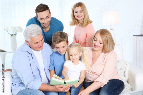 Happy family reading book in living room