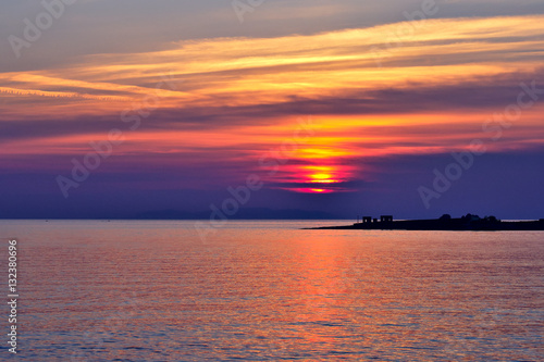 Beautiful Aegean Sea sunset with vibrant clouds. Greek travel destinations poster.. © jarnicek