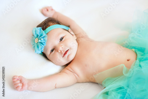 Happy newborn baby girl with hands up