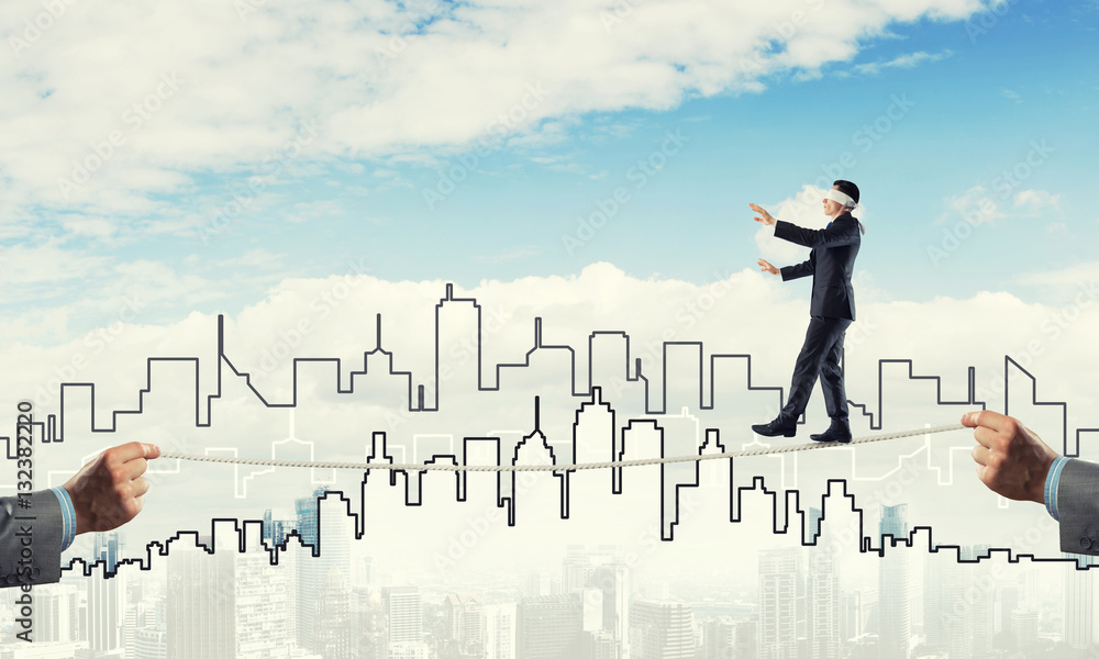 Business concept of risk support and assistance with man balancing on rope Business concept of risk support and assistance with man balancing on rope
