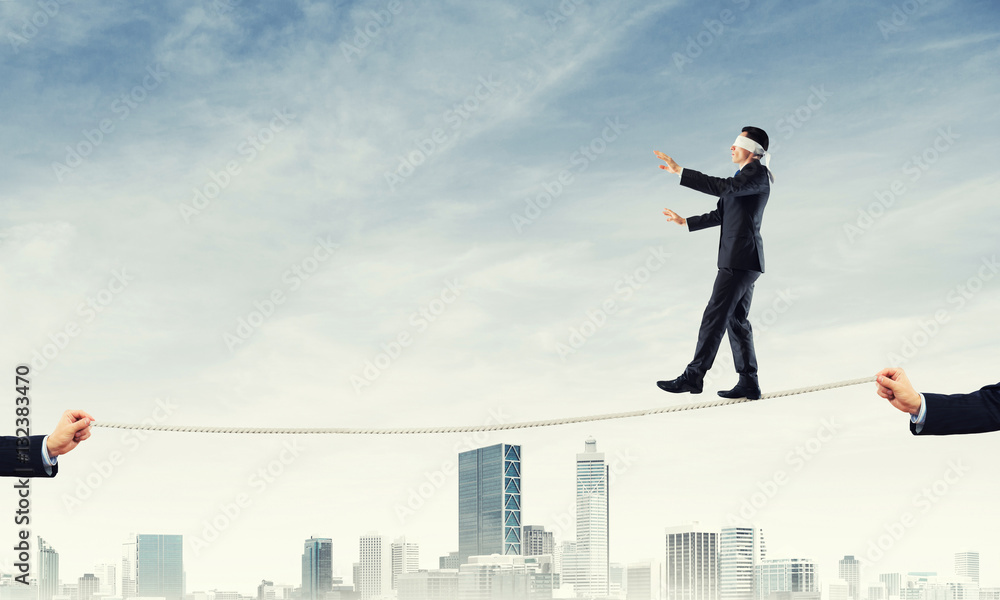 Business concept of risk support and assistance with man balancing on rope Business concept of risk support and assistance with man balancing on rope