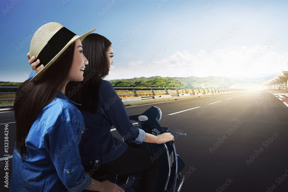 Obraz premium Two beautiful asian woman traveling by scooter