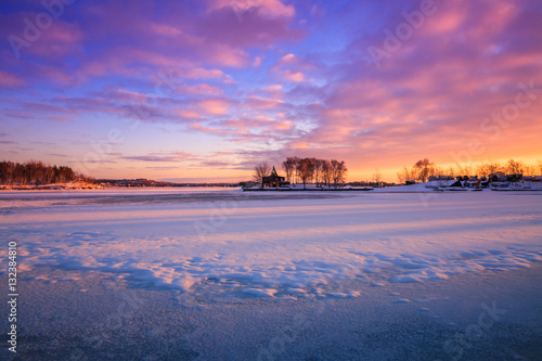 View of a frozen lake during sunrise in winter season. Location: Ramsey Lake, Ontario, Canada