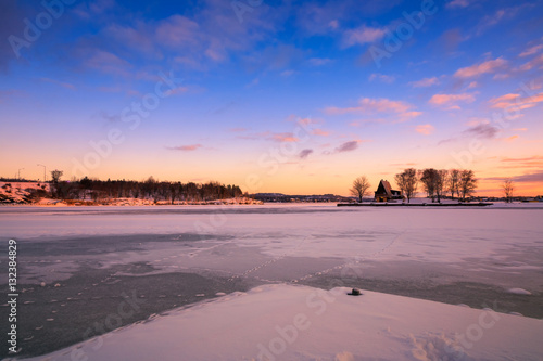 View of a frozen lake during sunrise in winter season. Location: Ramsey Lake, Ontario, Canada