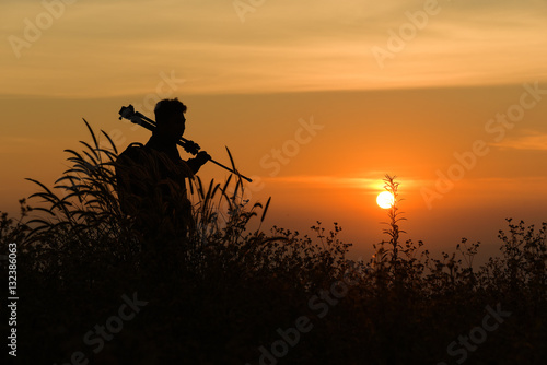 Silhouette of a young who like to travel and photographer, takin