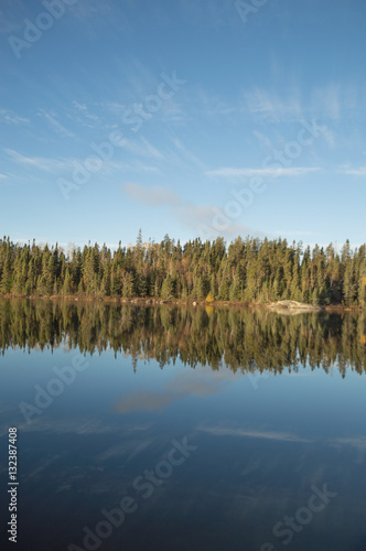 Calm Northern Ontario lake in early morning with reflected cloud