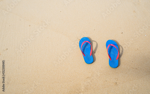 Blue flip flop on the clear sand beach