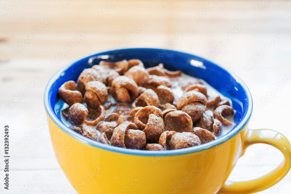 close-up a cup of fresh milk mixed with cereal and red spoon, prepare for breakfast, on wooden table close-up a cup of fresh milk mixed with cereal and red spoon, prepare for breakfast, on wooden table
