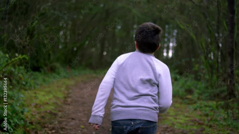 A little boy running away through a forest, slow motion A little boy running away through a forest, slow motion