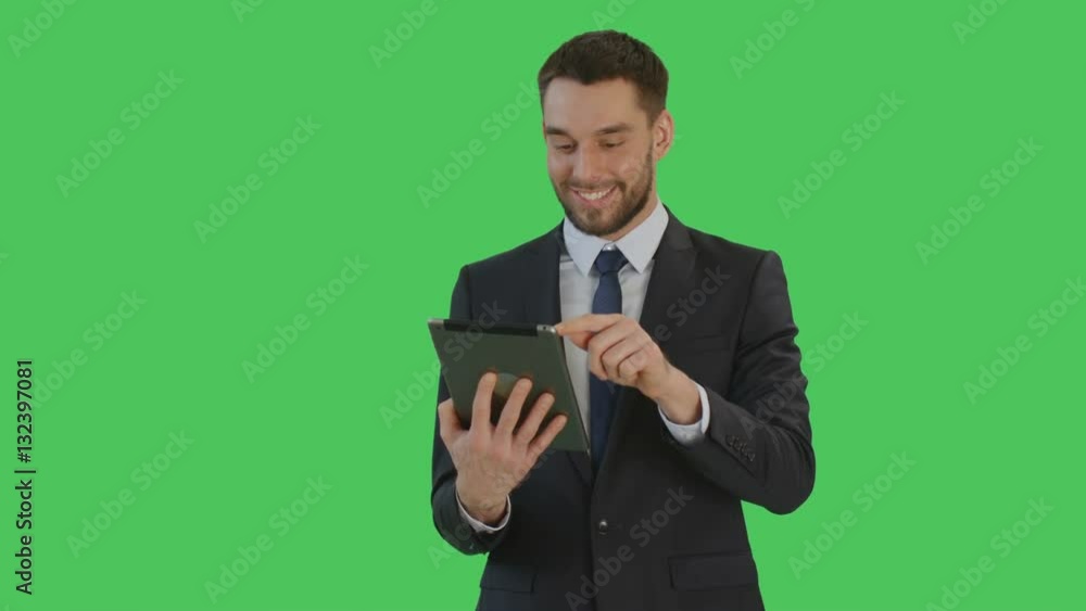 Medium Shot of a Smiling Handsome Businessman Makes Swiping Gestures on a Tablet Computer. Background is Green Screen. Shot on RED Cinema Camera 4K (UHD). Medium Shot of a Smiling Handsome Businessman Makes Swiping Gestures on a Tablet Computer. Background is Green Screen. Shot on RED Cinema Camera 4K (UHD).