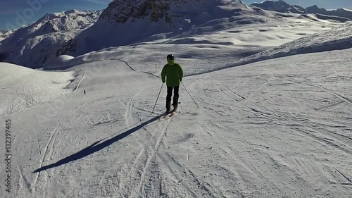 Slow motion: Man is skiing down along the slope on sunny day, Tignes, France