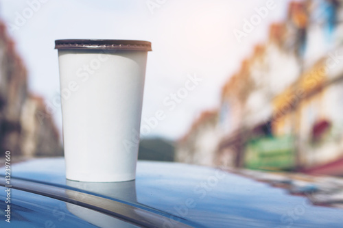 Takeaway paper cup on the roof of car that it may forgot on the rush hour.