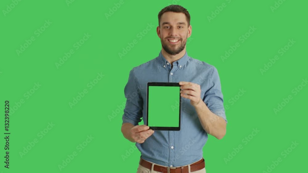 Mid Shot of a Smiling Man on Presenting Vertically Tablet Computer with Green Screen. Green Screen in Background. Shot on RED Cinema Camera 4K (UHD). Mid Shot of a Smiling Man on Presenting Vertically Tablet Computer with Green Screen. Green Screen in Background. Shot on RED Cinema Camera 4K (UHD).