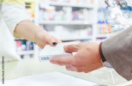 Man shopping at the pharmacy. Taking over a medicine.
hands close up