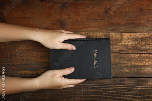 Women's hands holding the Bible. Top view.The concept of religion. photo