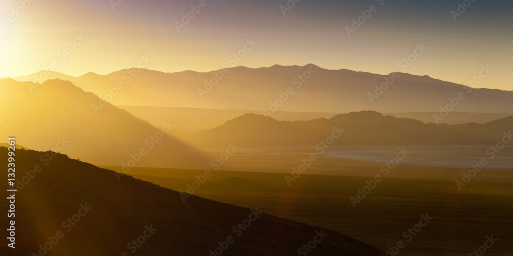 Desert landscape sunset with sun flare and haze