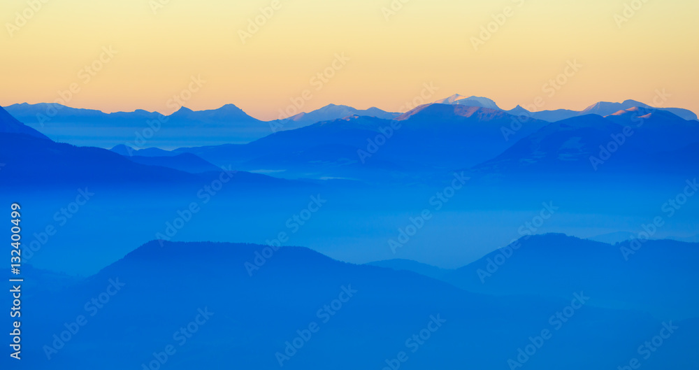 Colorful dusk in the French mountains, with the valley filled with fog.