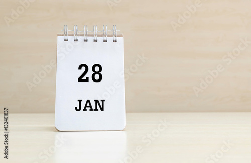 Foto Closeup surface note book with black 28 jan word in page on blurred brown wood d