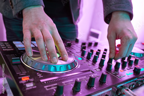 DJ plays and mix music on digital midi mixer controller. photo