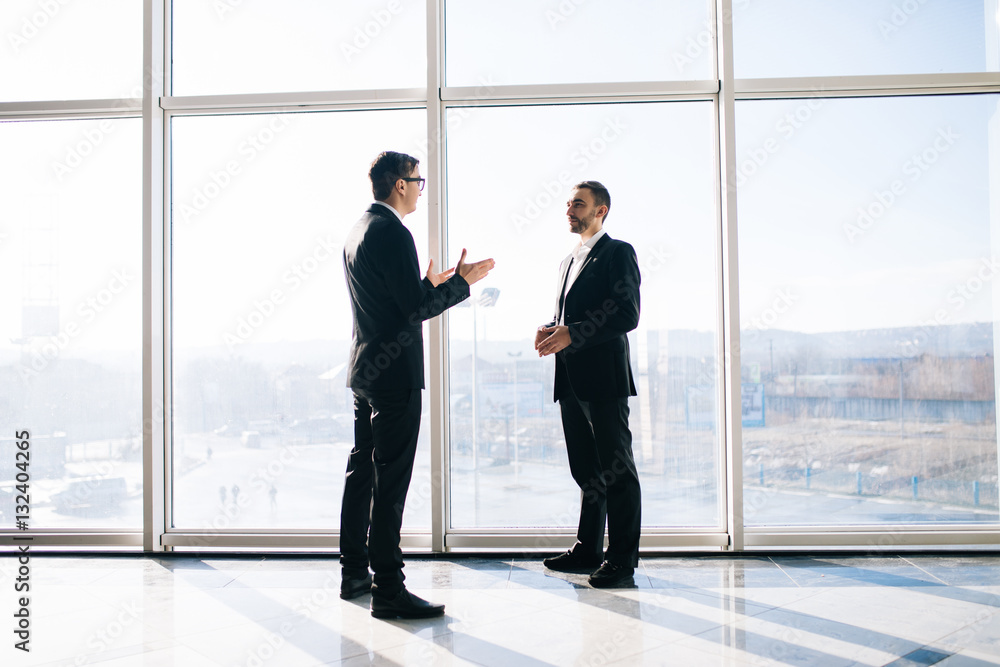 Two businessmen dicussing business perspectives in office Two businessmen dicussing business perspectives in office