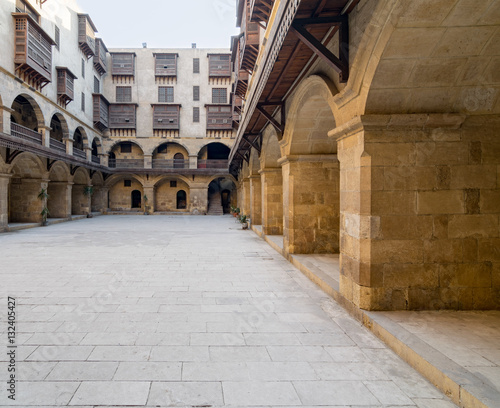 Facade of caravansary (Wikala) of Bazaraa, with vaulted arcades and windows covered by interleaved wooden grids (mashrabiyya), suited in Tombakshia street, Al Gamalia district, Medieval Cairo, Egypt photo