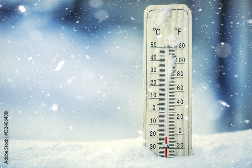 Thermometer on snow shows low temperatures under zero. Low temperatures in degrees Celsius and fahrenheit. Cold winter weather twenty under zero.