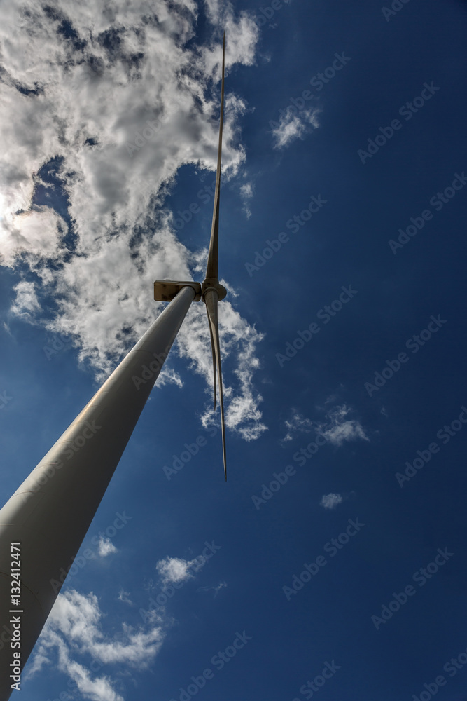 View from below of a large windmill on a sunny day
