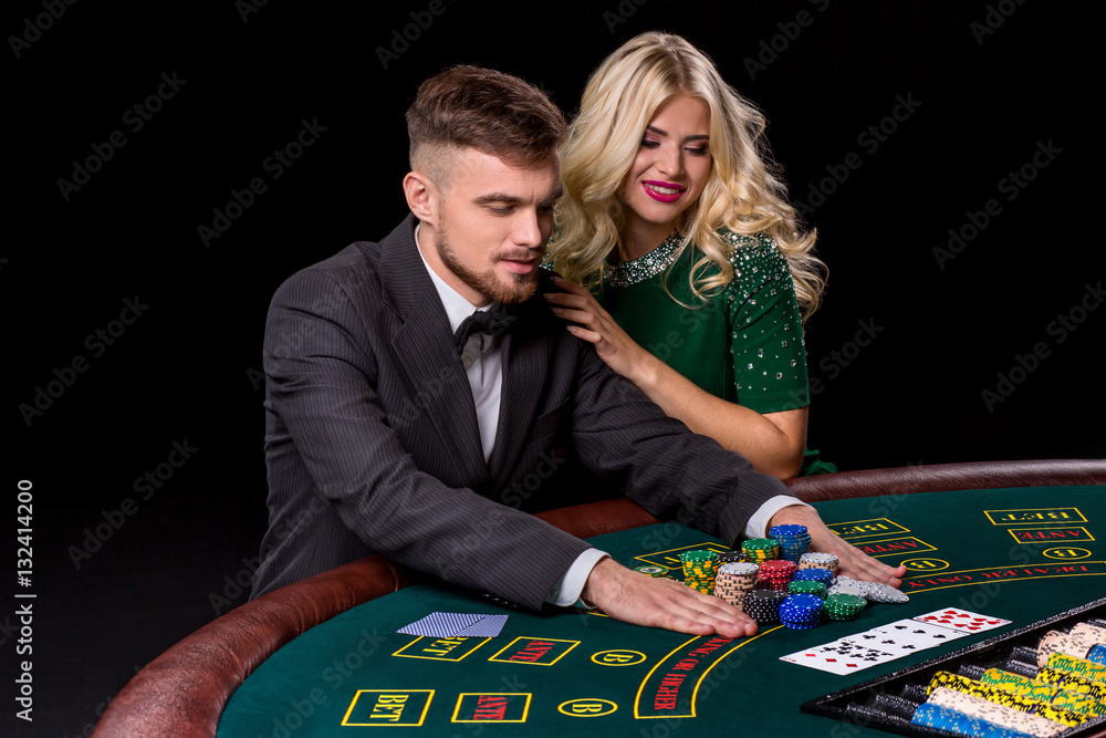 View of young, confident, man with the lady while he's playing poker game. View of young, confident, man with the lady while he's playing poker game.