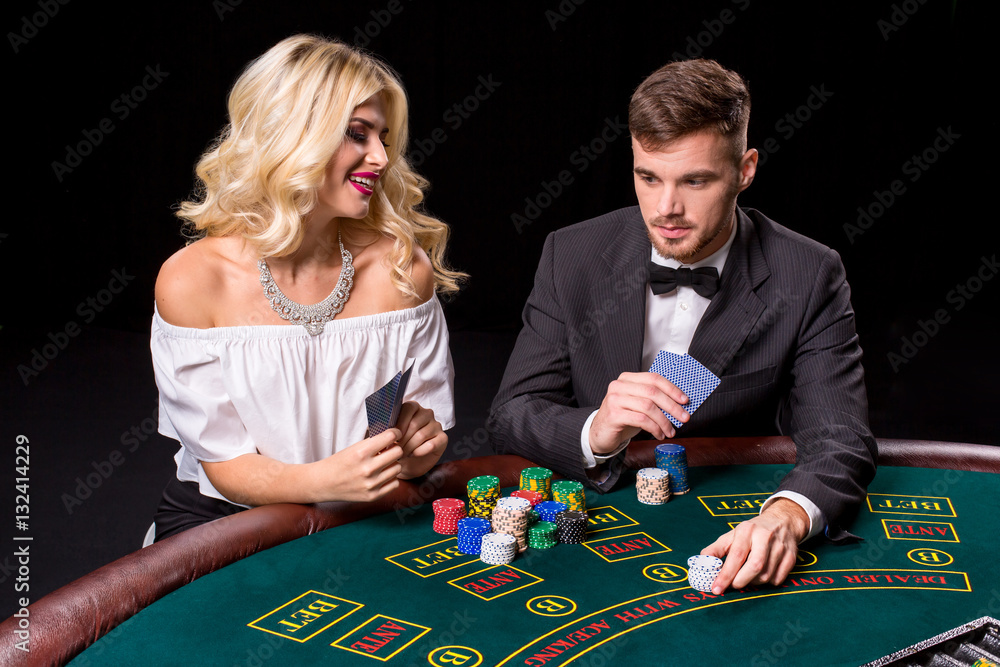 View of young, confident, man with the lady while he's playing poker game. View of young, confident, man with the lady while he's playing poker game.