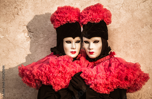 Couple de jumelles, élégance, raffinement et beauté, costume et masque vénitien durant le Carnaval de Venise en Italie