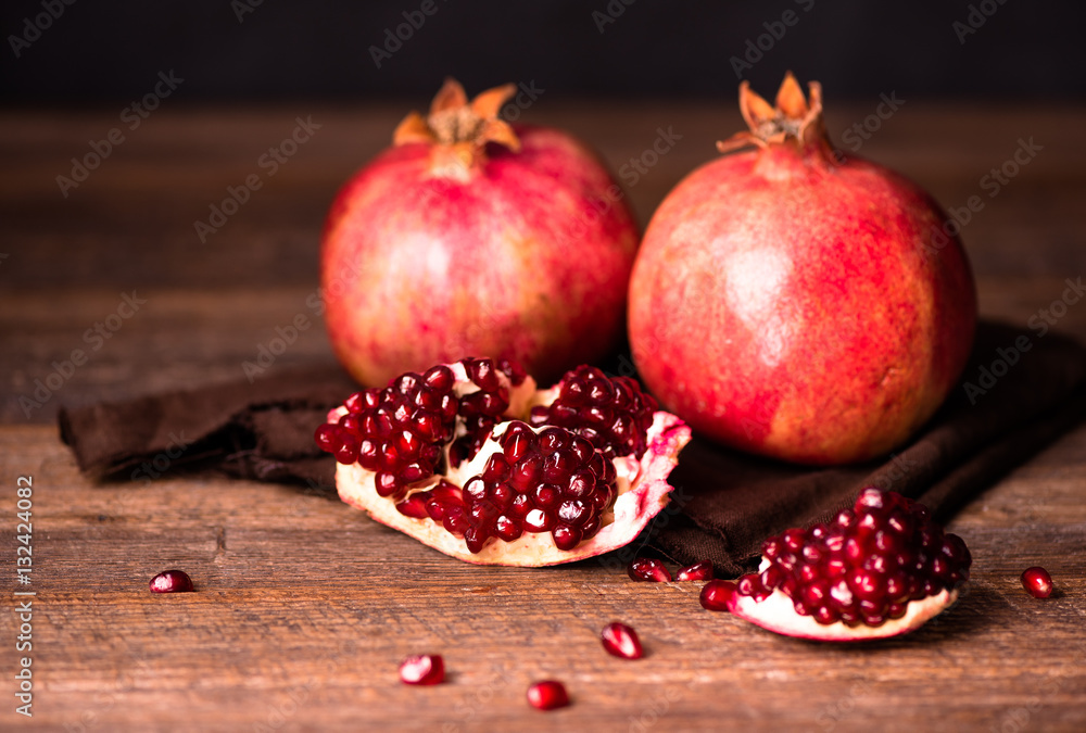 Pomegranate fruits with grains on wooden table. Pomegranate fruits with grains on wooden table.