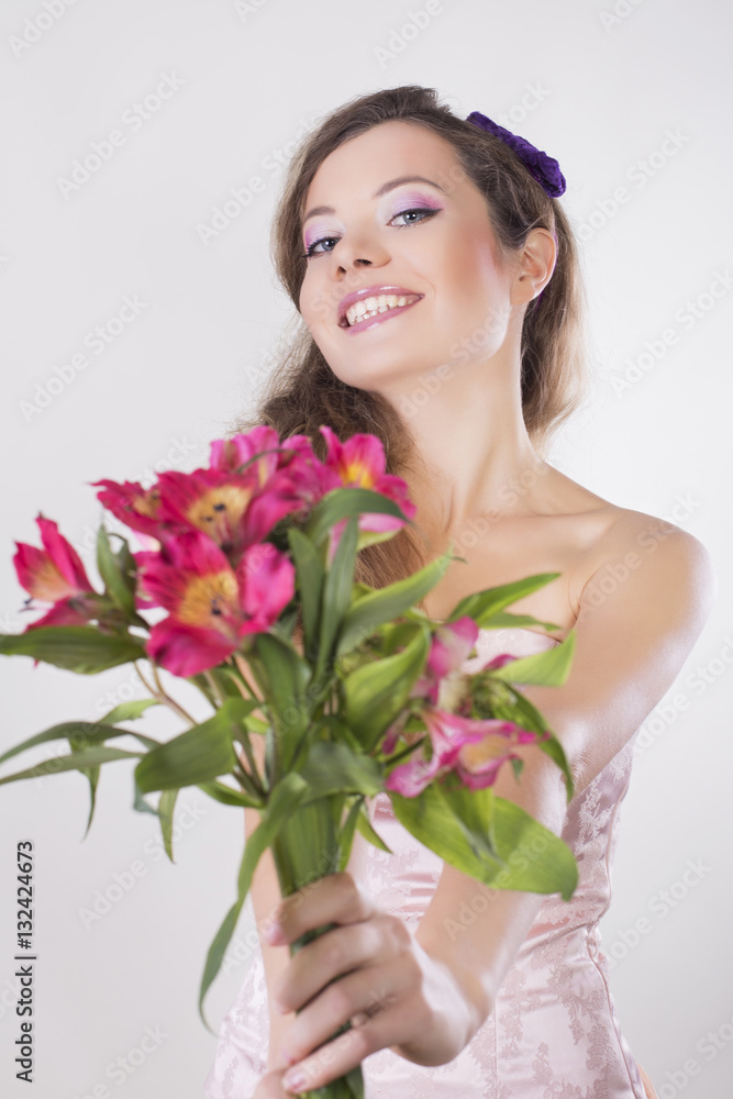 Beautiful happy girl give a wild orchid violet flowers