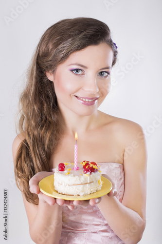 Beautiful happy girl propose a birthday cake with candle
