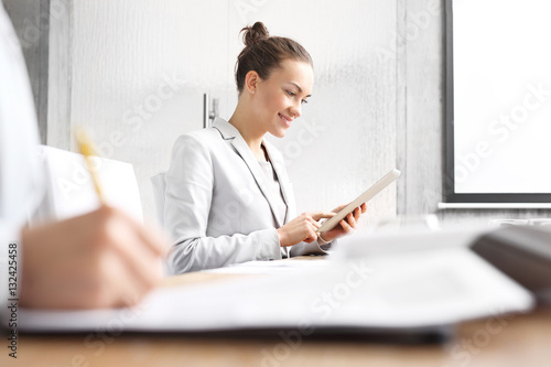 Businesswoman w gabinecie.Businesswoman czyta na tablecie siedząc w sali konferencyjnej