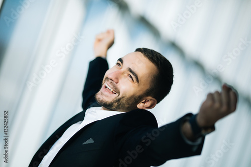Happy Businessman executive raising fists in excitement in office