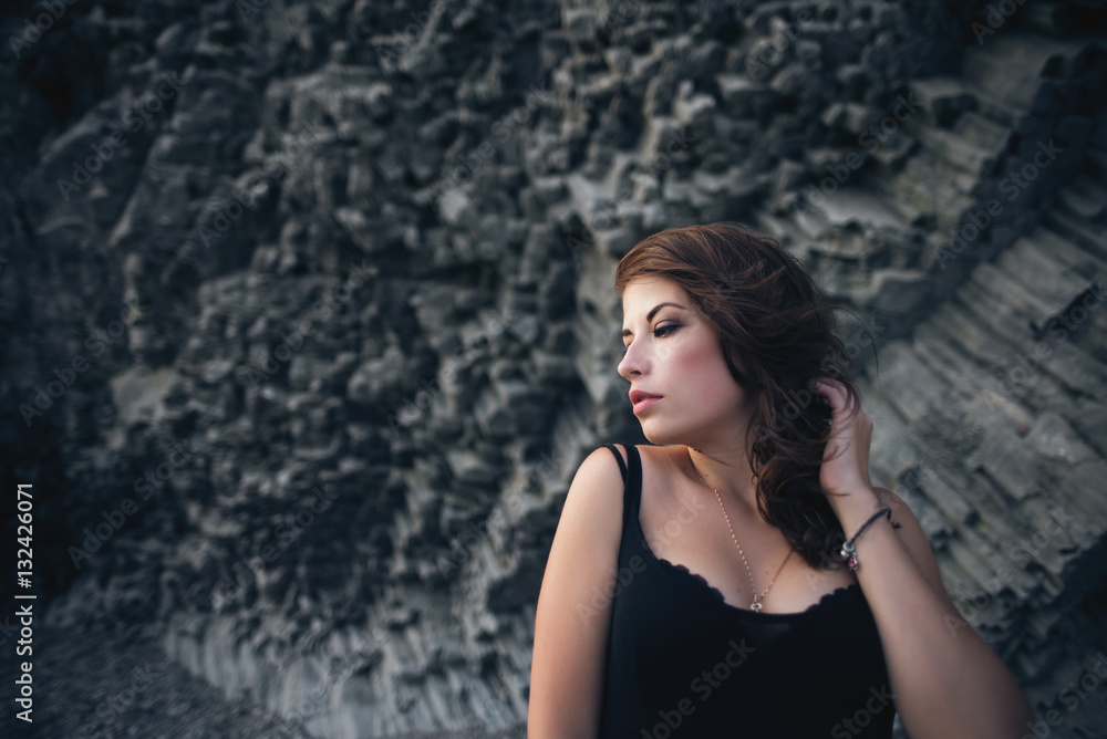 Sexy model in dress posing against the backdrop of the rock Sexy model in dress posing against the backdrop of the rock