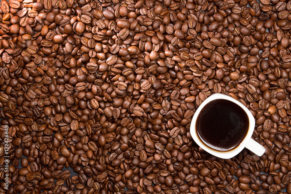 Coffee background. Coffee beans and cup of coffee over table. Coffee background. Coffee beans and cup of coffee over table.