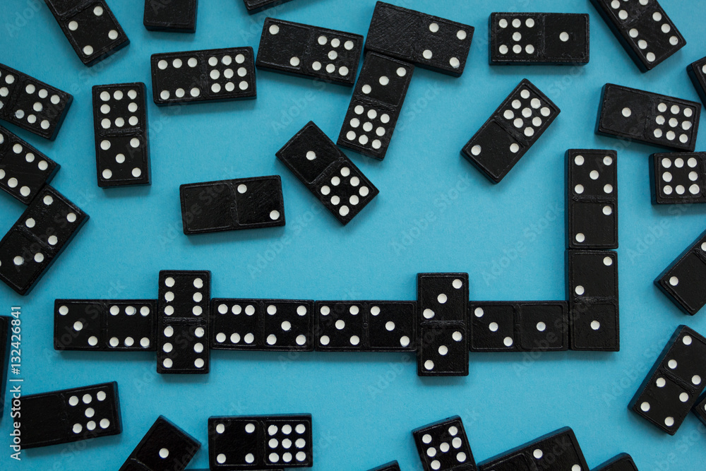 Line of domino pieces on the blue background, view from top Line of domino pieces on the blue background, view from top