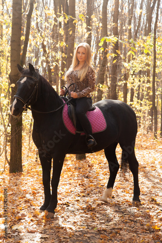 Girl on a walk in the autumn forest on horseback © izida1991