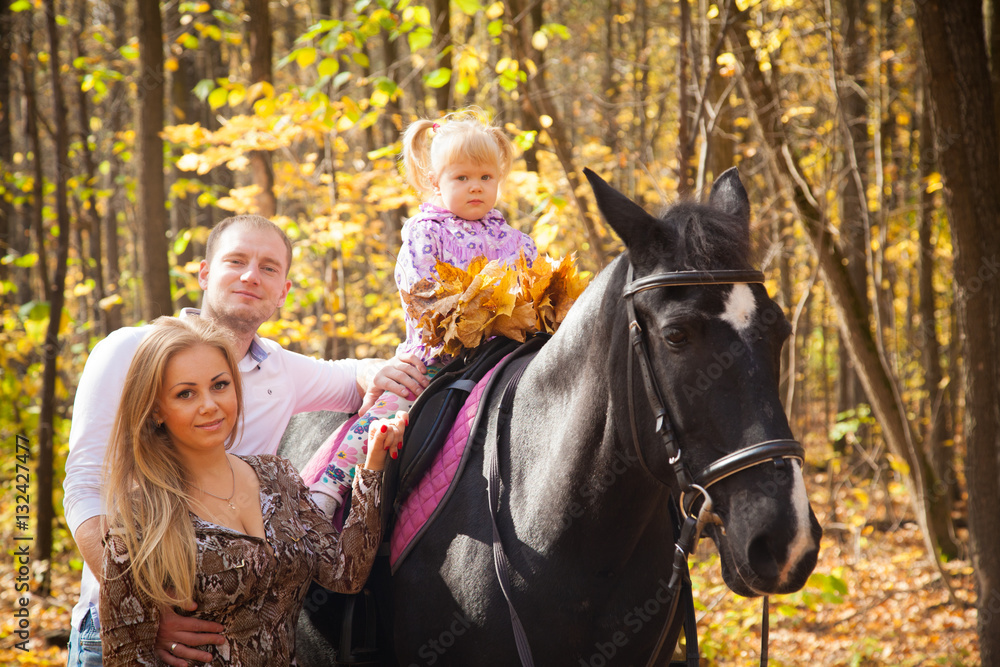 young family walking in the autumn forest with a horse young family walking in the autumn forest with a horse