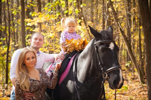 young family walking in the autumn forest with a horse © izida1991