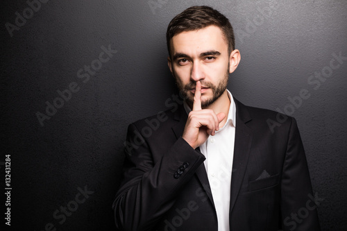 Young businessman in suit Silence isolated on black