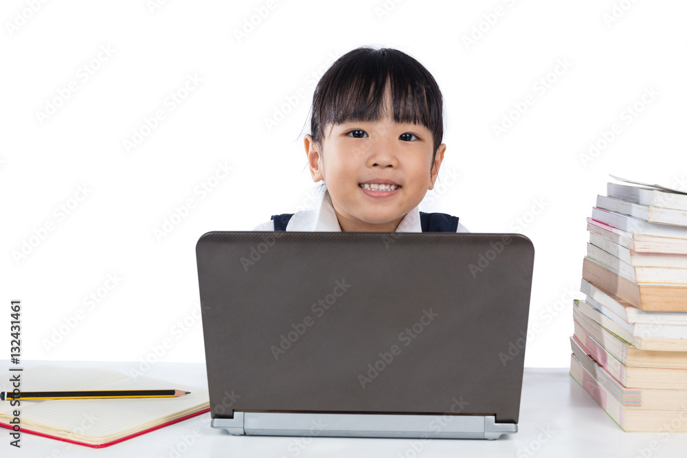 Happy Asian Chinese little girl wearing school uniform using lap Happy Asian Chinese little girl wearing school uniform using lap
