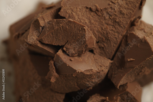 chunks of gianduja hazelnut milk chocolate on paper, closeup photo photo