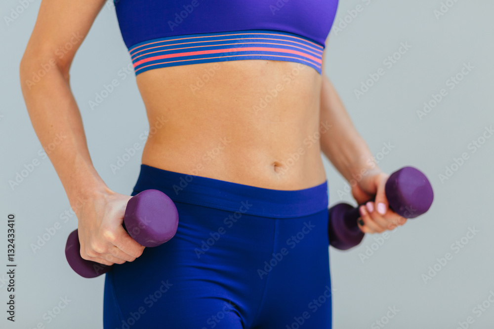 Close-up of torso of female holding barbells Close-up of torso of female holding barbells